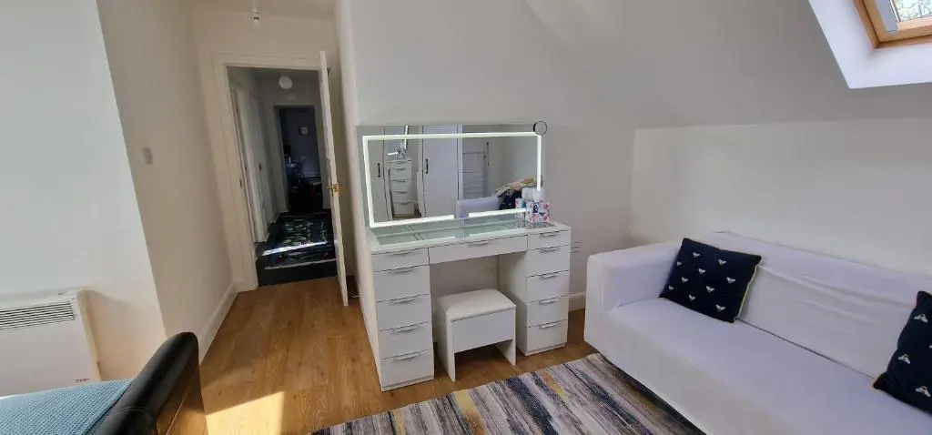 a living room with a white couch and a mirror at The Flat at Clocktower Buildings in Kinloss