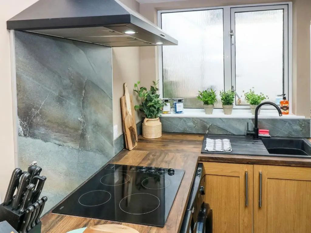 a kitchen with a sink and a stove top oven at West Pier Cottage in Macduff