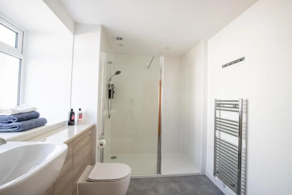 a bathroom with a shower and a toilet and a sink at Cairnie Cottage in Ballater