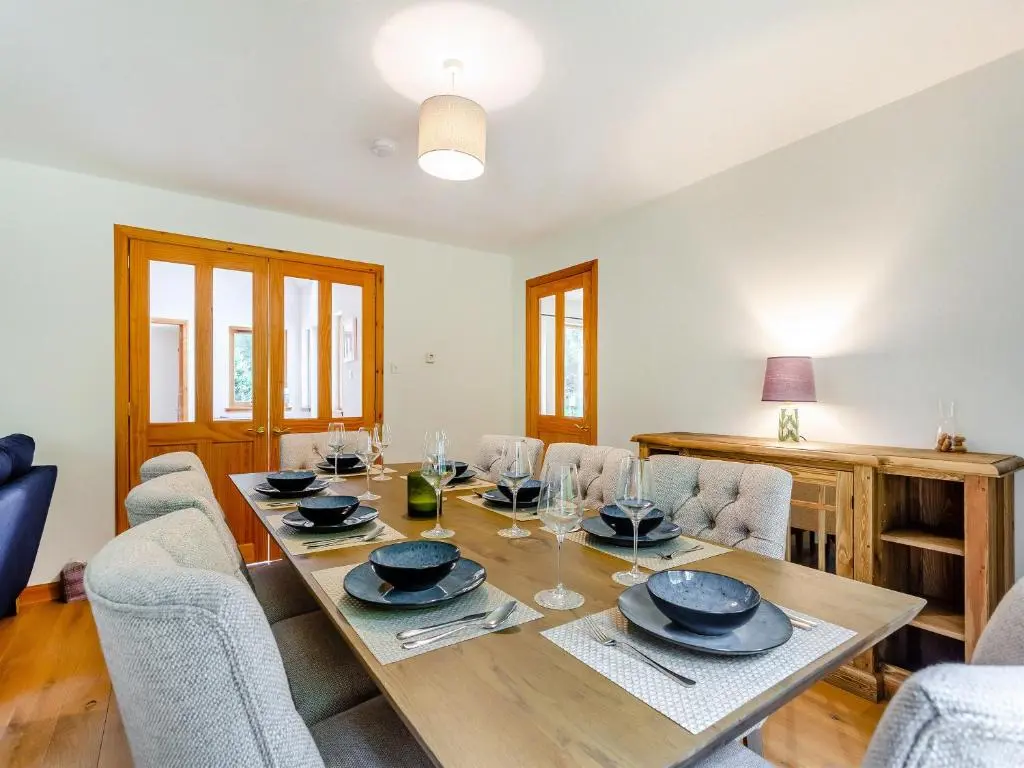 a dining room with a wooden table and chairs at Bridge House in Evanton