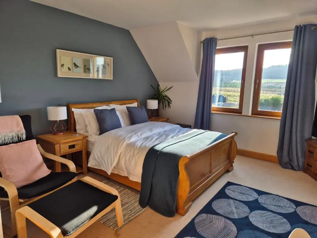 a bedroom with a bed and a chair at Twin Pines in Mulben