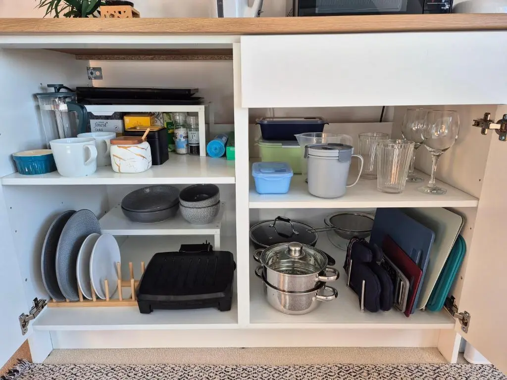a white cabinet filled with dishes and utensils at Twin Pines in Mulben