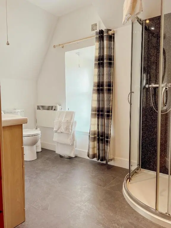 a bathroom with a shower and a toilet at Loch Ness Gatehouse Apartments in Fort Augustus