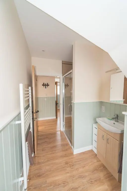 an attic bathroom with a sink and a mirror at Cosy Spacious Highland Cottage in Craggie