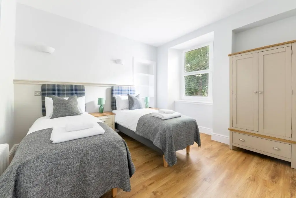 a bedroom with two beds and a window at Hillside Luxury Apartments in Inverness