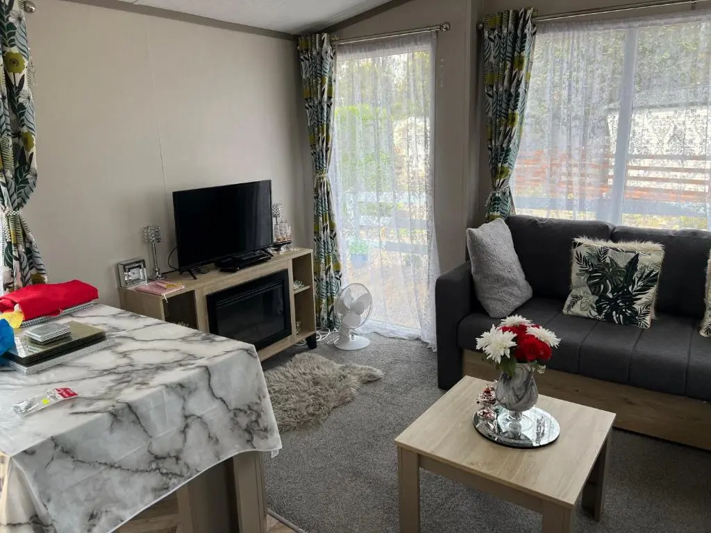 a living room with a couch and a tv at 44 Angels Retreat in Boat of Garten