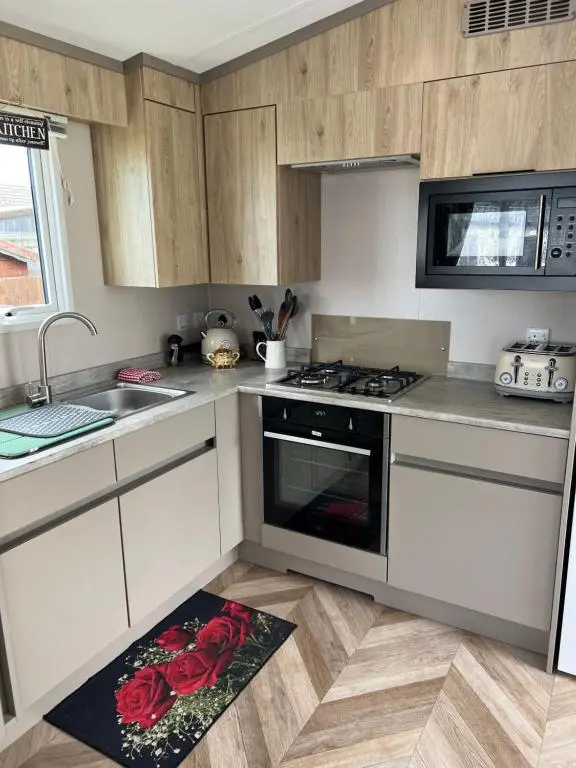 a kitchen with a stove top oven next to a sink at 44 Angels Retreat in Boat of Garten