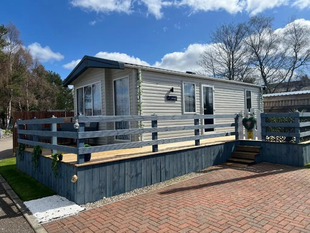 a tiny house with a large wooden deck at 44 Angels Retreat in Boat of Garten