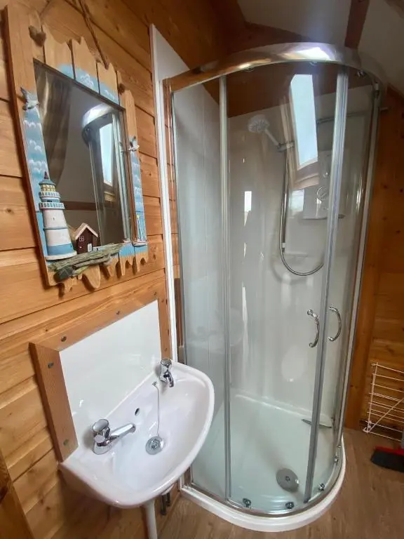 a bathroom with a shower and a sink at Greenley Croft Glamping by Wigwam in Crovie
