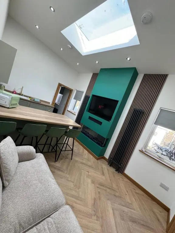 a living room with a couch and a table and a tv at Cosy Luxury apartment in Wick