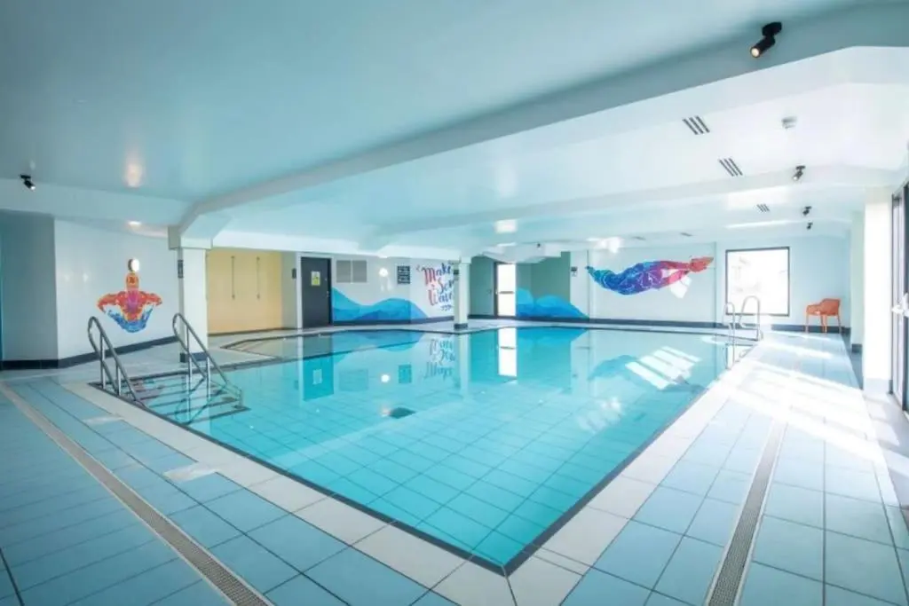 a large swimming pool with blue tiles on the floor at Sea La Vie Caravan at Silver Sands Holiday Park in Lossiemouth