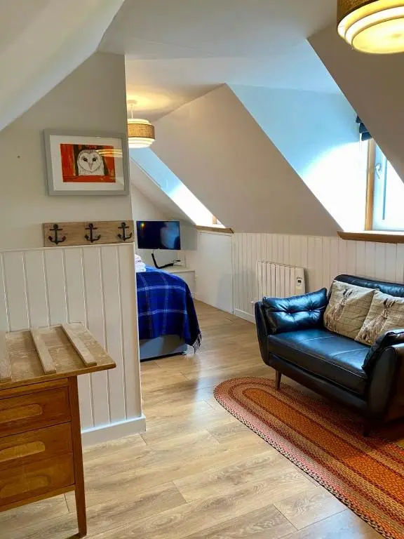a living room with a couch and a bed at Highland Rooms - Room Only No Breakfast in Ullapool