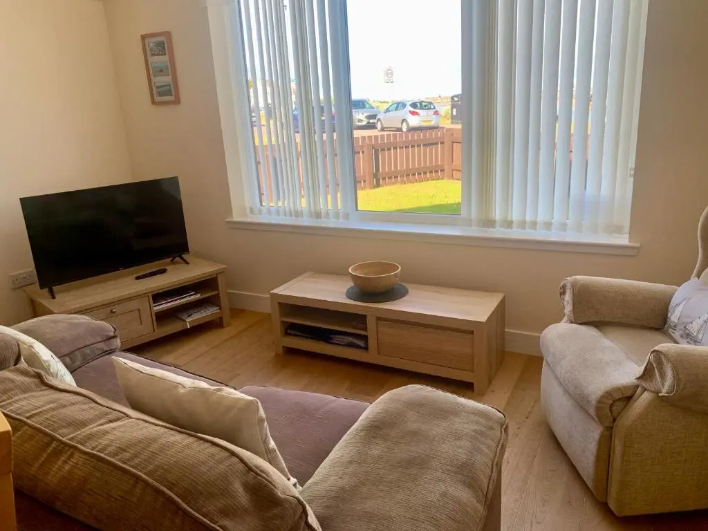 a living room with two couches and a flat screen tv at The Annexe in Lossiemouth