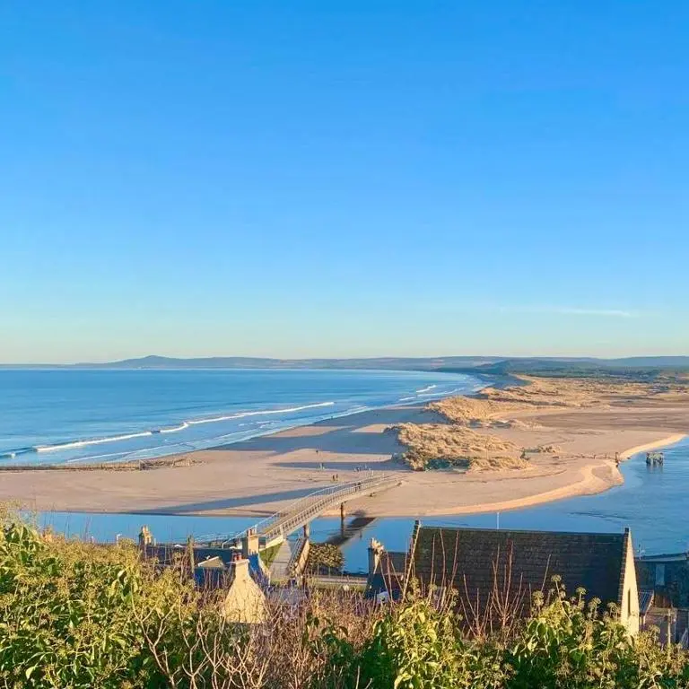 a view of a beach with the ocean and a town at The Annexe in Lossiemouth