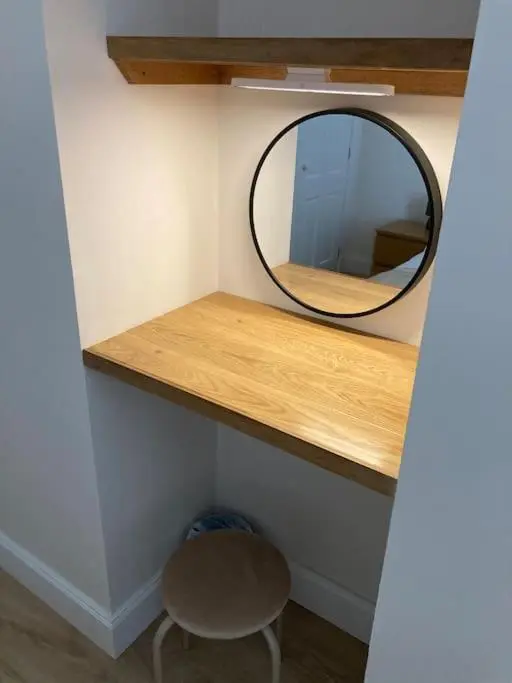 a mirror on a shelf with a chair and a stool at One bedroom Flat in Dingwall in Dingwall