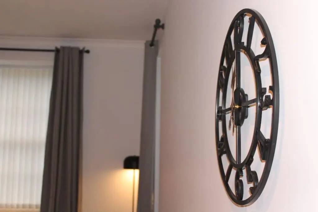 a large clock hanging on a wall in a room at One bedroom Flat in Dingwall in Dingwall