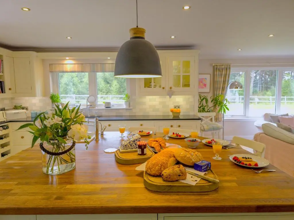 a kitchen with a table with food on it at The Bellhouse - hot tub lodge in Tomatin in Tomatin