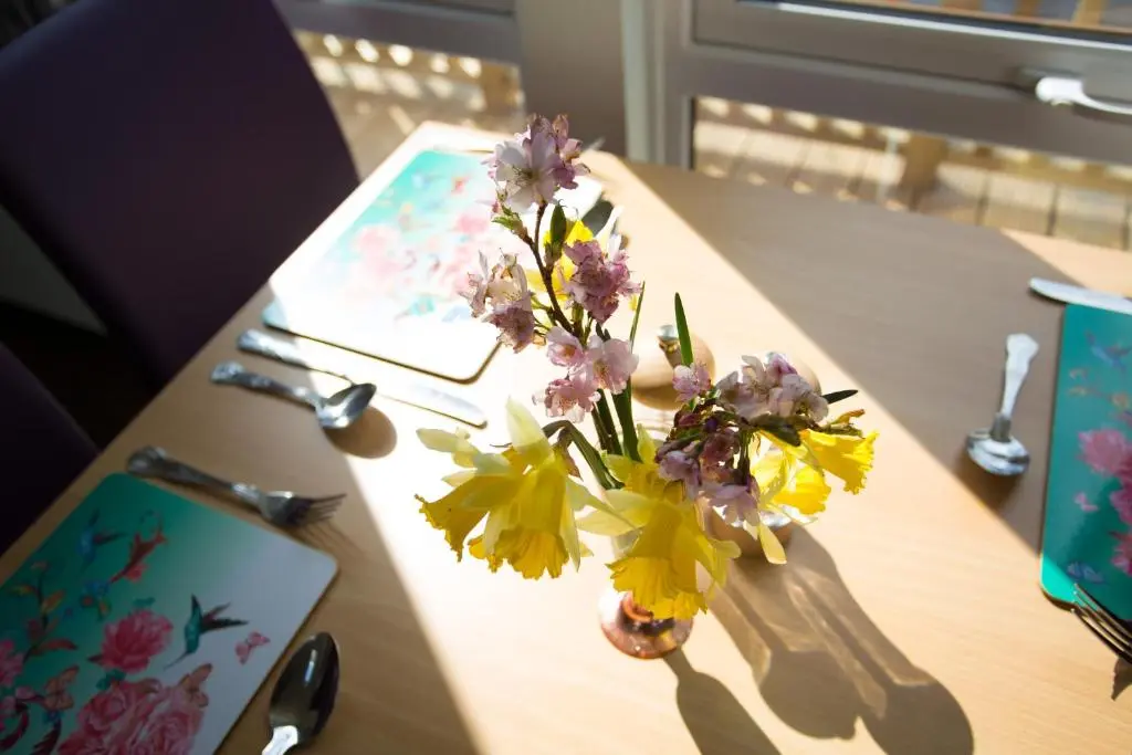 a vase filled with flowers on a table at Bluebell Lodge - Sleeps 4 Loch & Woodland in Strathpeffer