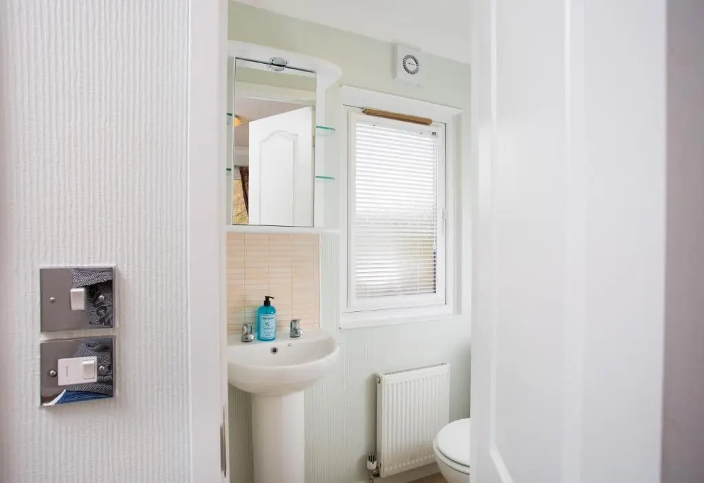 a bathroom with a sink and a mirror at Bluebell Lodge - Sleeps 4 Loch & Woodland in Strathpeffer