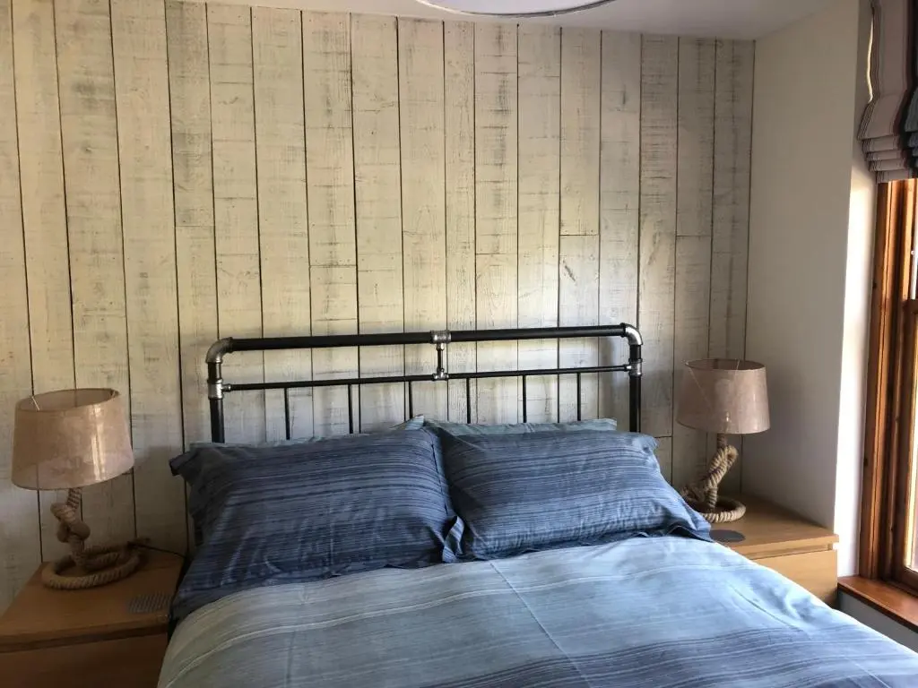 a bed with blue pillows in a bedroom with two lamps at The Three Kings Inn in Cullen
