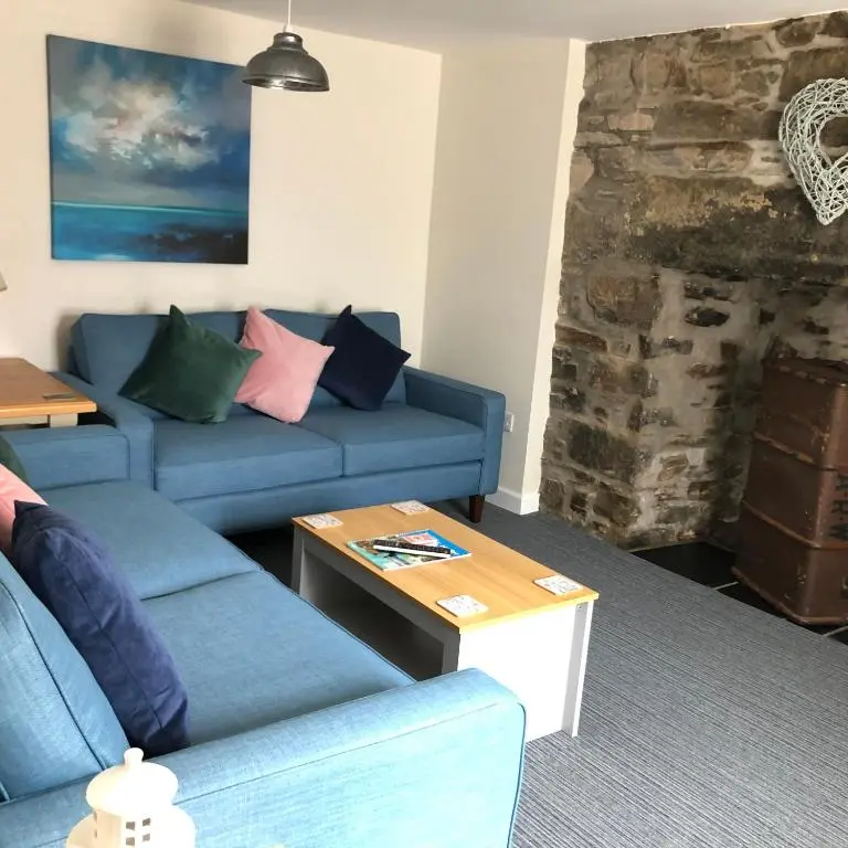 a living room with a blue couch and a table at The Three Kings Inn in Cullen