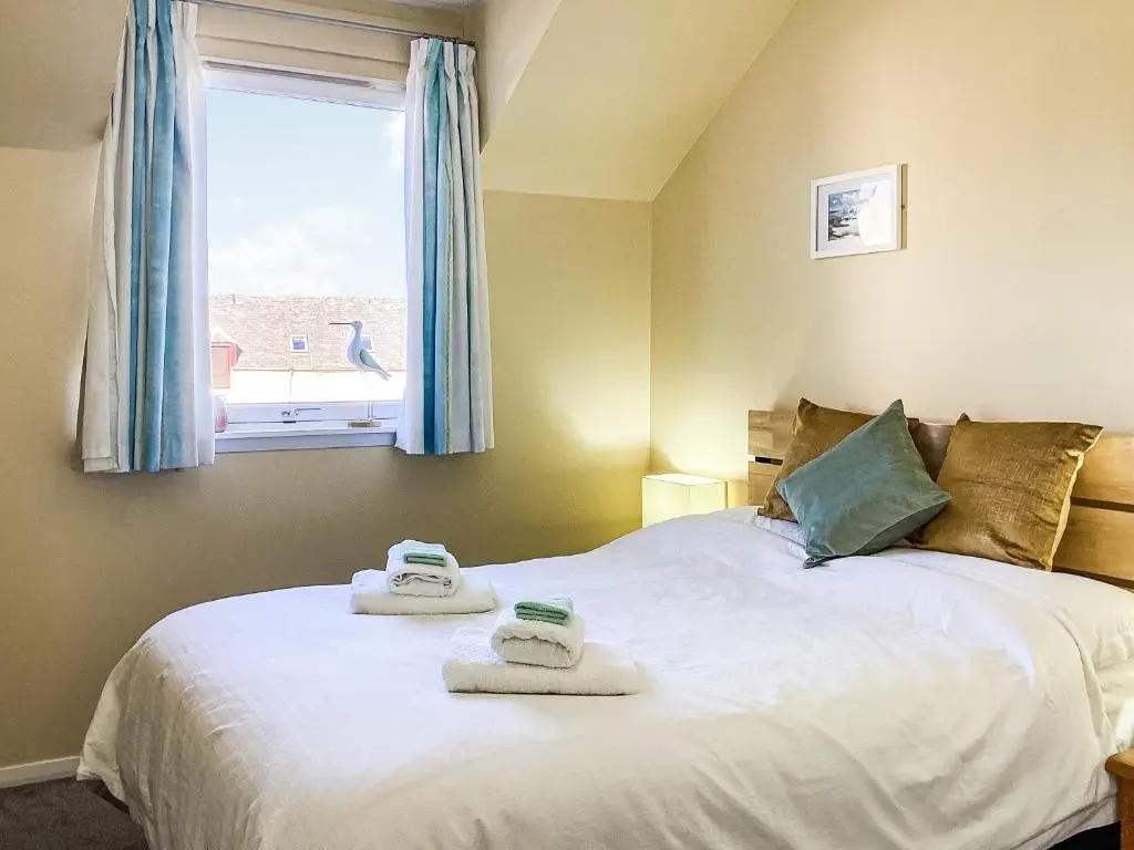 a bedroom with a bed with towels on it at Taigh Na Tunnagan in Nairn