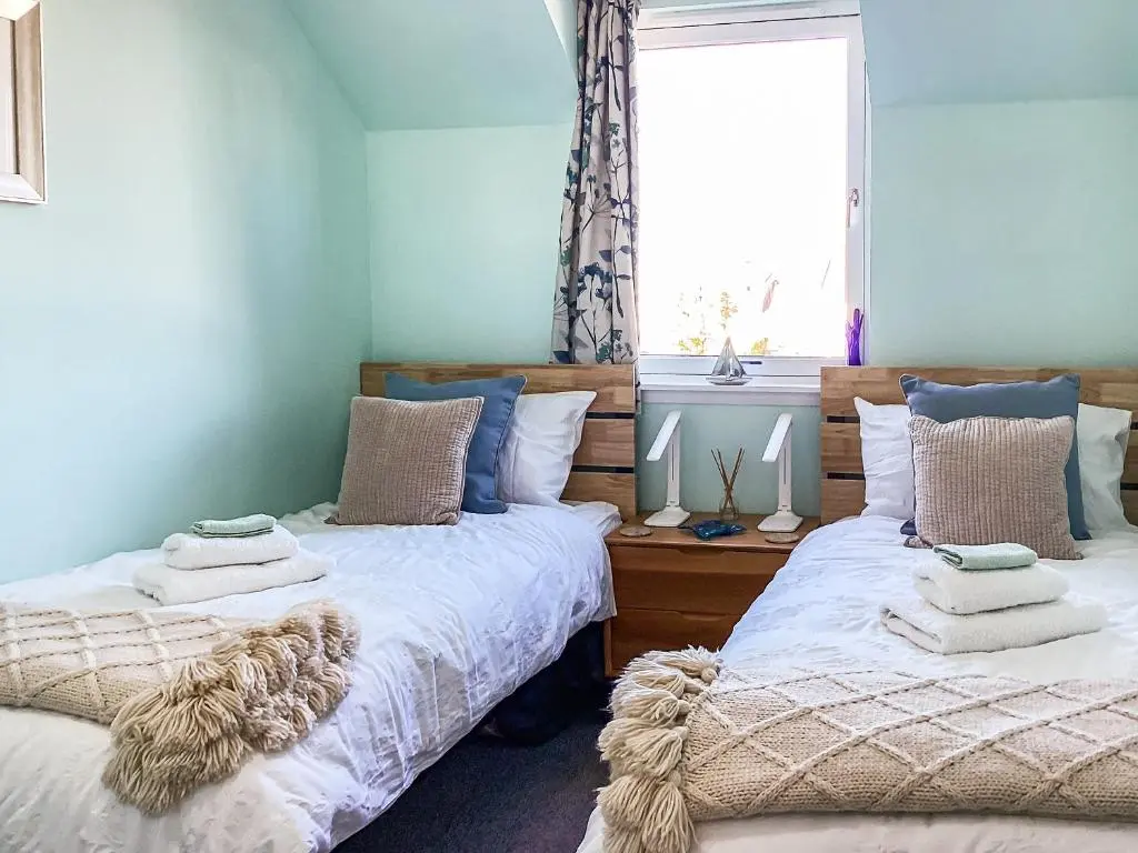 two beds sitting next to each other in a bedroom at Taigh Na Tunnagan in Nairn