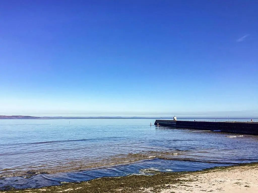 a pier in the water next to a beach at Taigh Na Tunnagan in Nairn