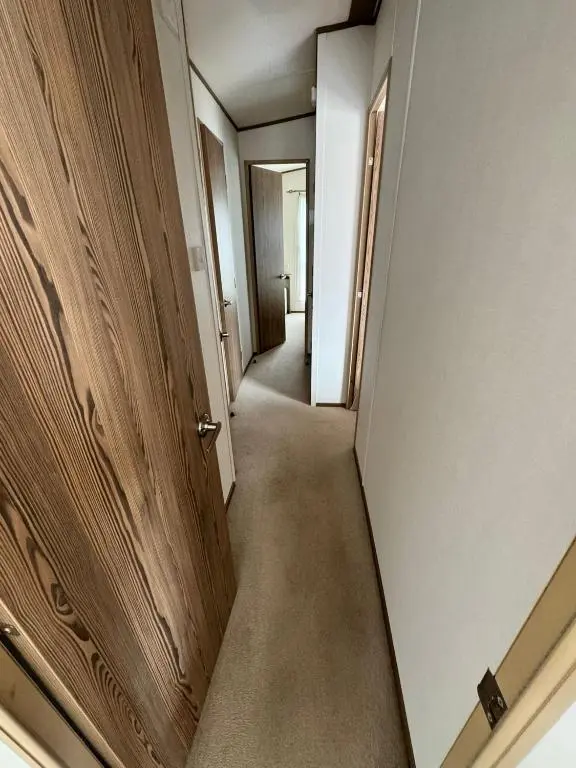 a corridor of an empty room with a door at Jandor Retreat in Lossiemouth