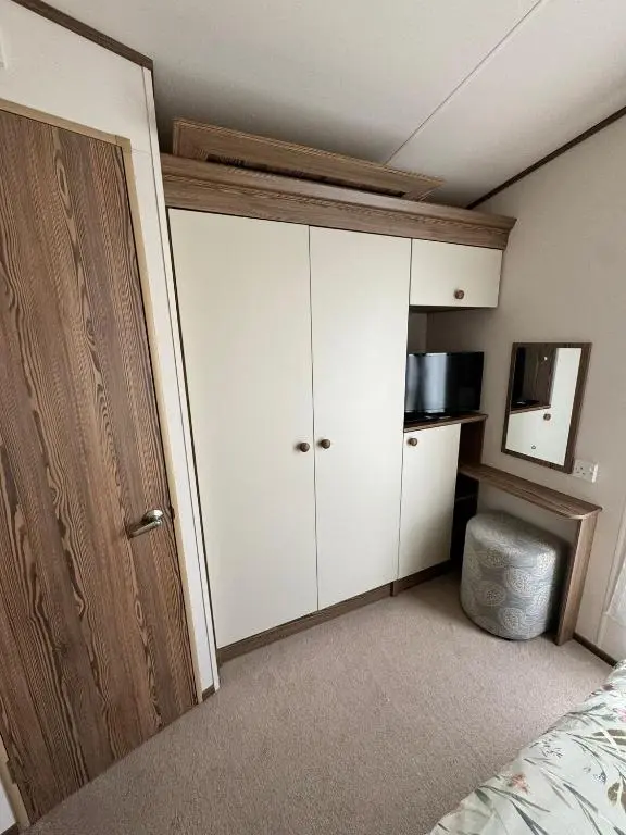 a bedroom with a white cabinet and a bed at Jandor Retreat in Lossiemouth