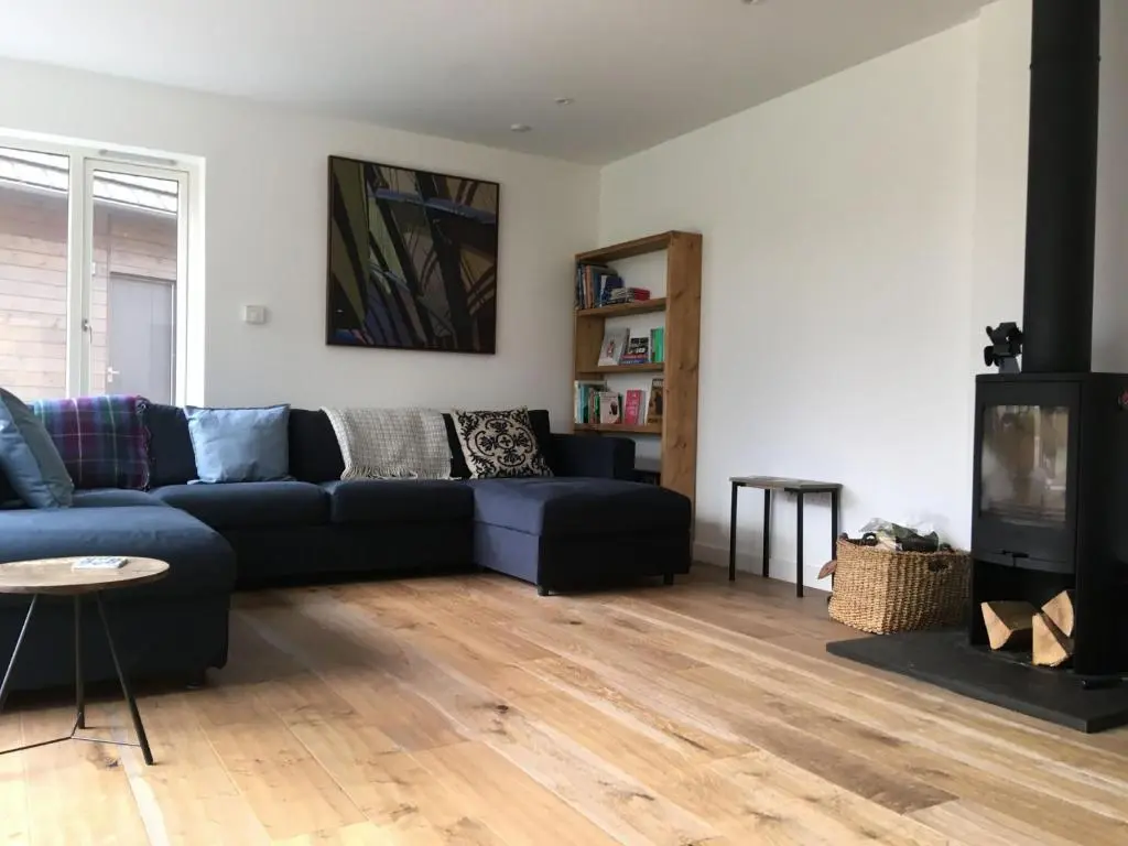 a living room with a blue couch and a tv at St Vincents in Kingussie