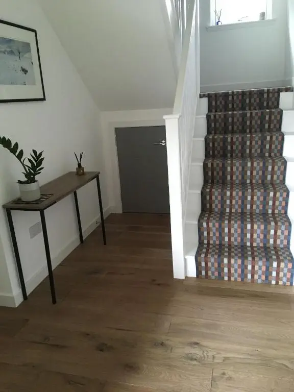 a room with a staircase with a stack of dvds at St Vincents in Kingussie