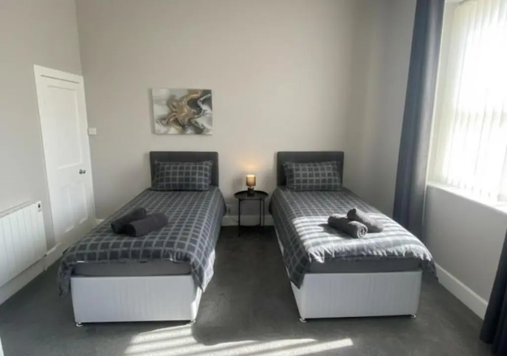 two beds in a bedroom with a window at Frithside Retreat 3BR Sleeps 7 Coastal Getaway in Fraserburgh