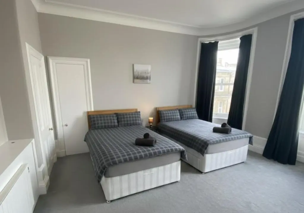 a bedroom with two beds and a window at Frithside Retreat 3BR Sleeps 7 Coastal Getaway in Fraserburgh