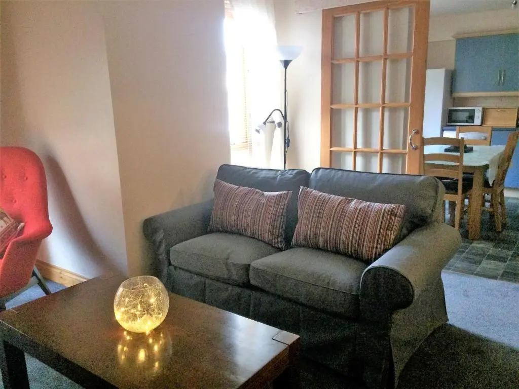 a living room with a couch and a coffee table at Dunroamin Self-Catering Apartment in Aviemore
