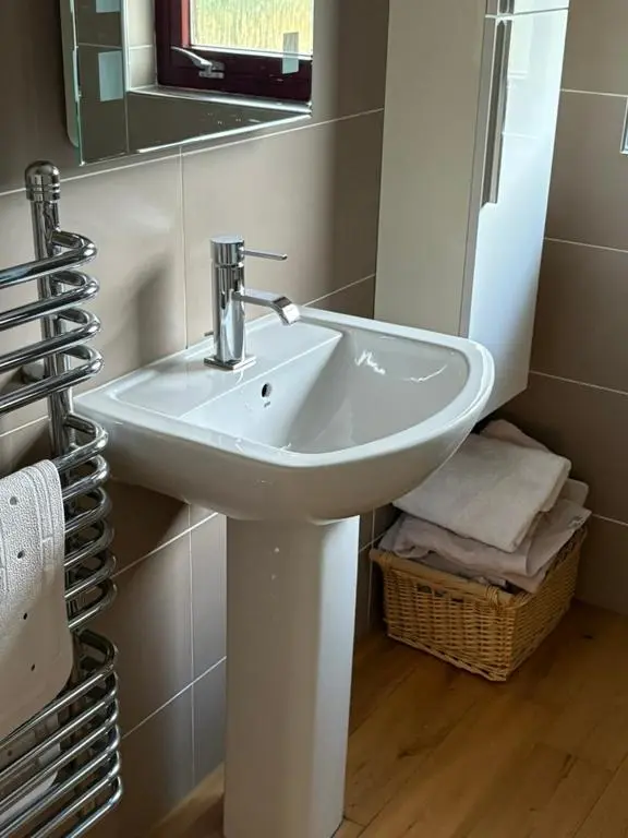 a white sink in a bathroom with a mirror at Craigie View Aviemore in Aviemore