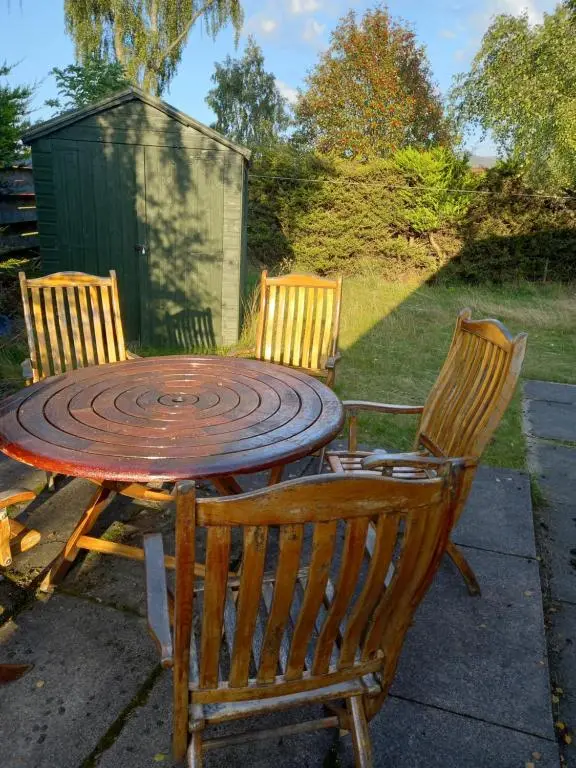 a wooden table with two chairs and a table with at Craigie View Aviemore in Aviemore