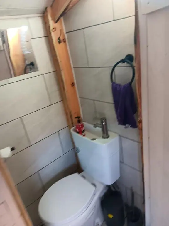 a small bathroom with a toilet and a sink at Archie The Double Decker Bus in Tain
