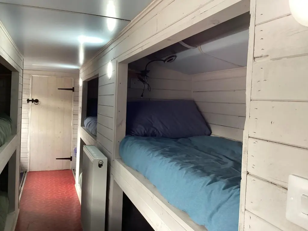 a bed in a small room with a wall at Archie The Double Decker Bus in Tain