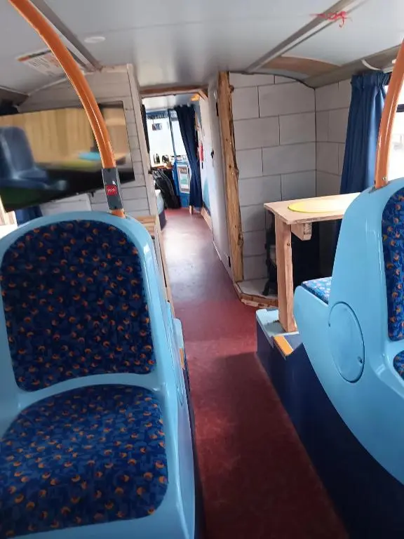 a room with chairs and a table in a bus at Archie The Double Decker Bus in Tain