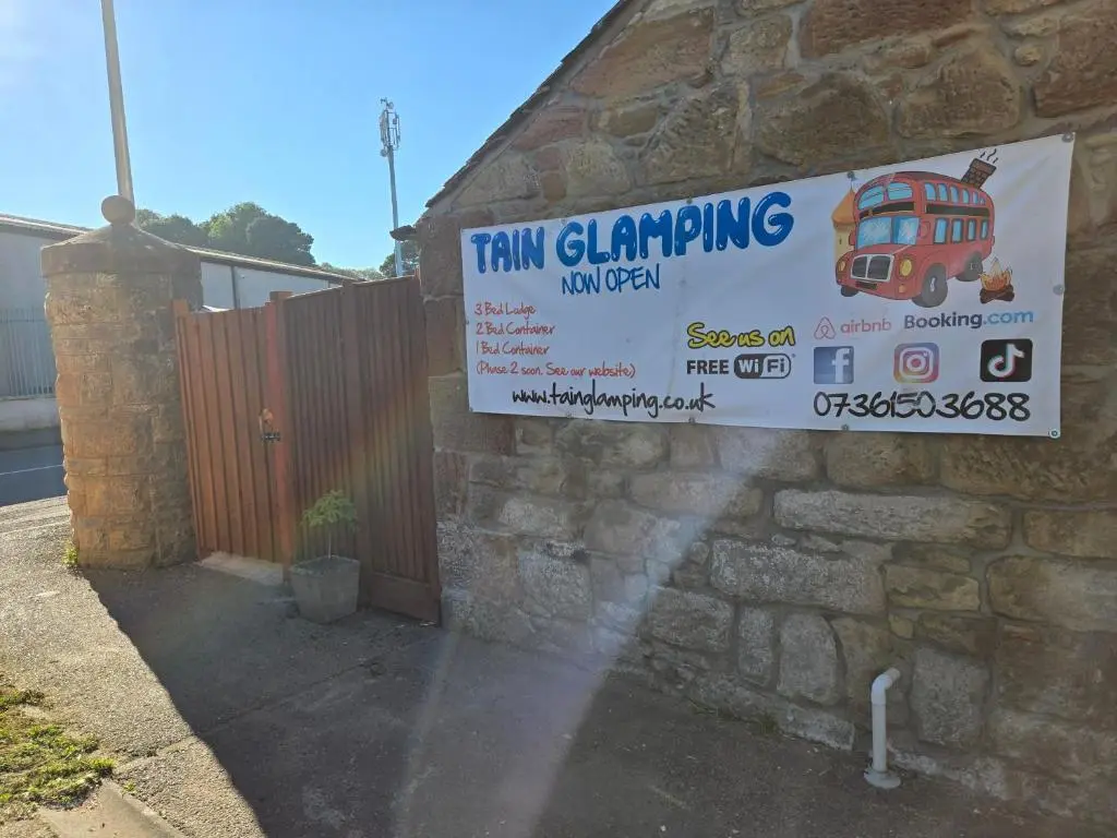a sign on the side of a building with a bus sign at The Wee Bothy in Tain