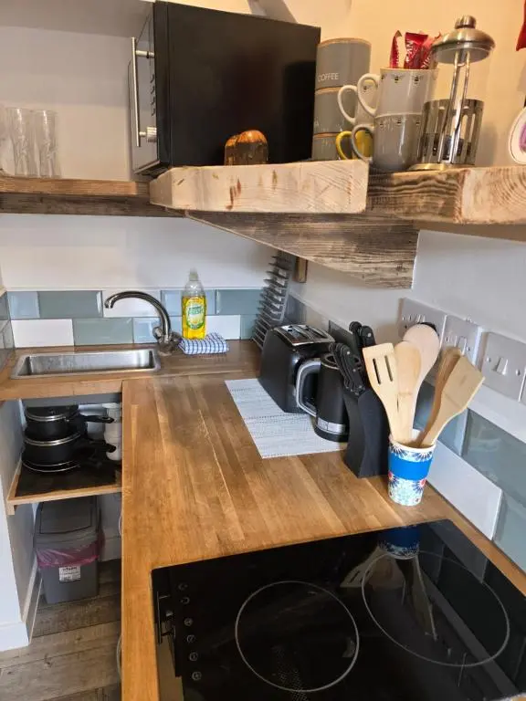 a kitchen with a wooden counter top with a stove at The Wee Bothy in Tain
