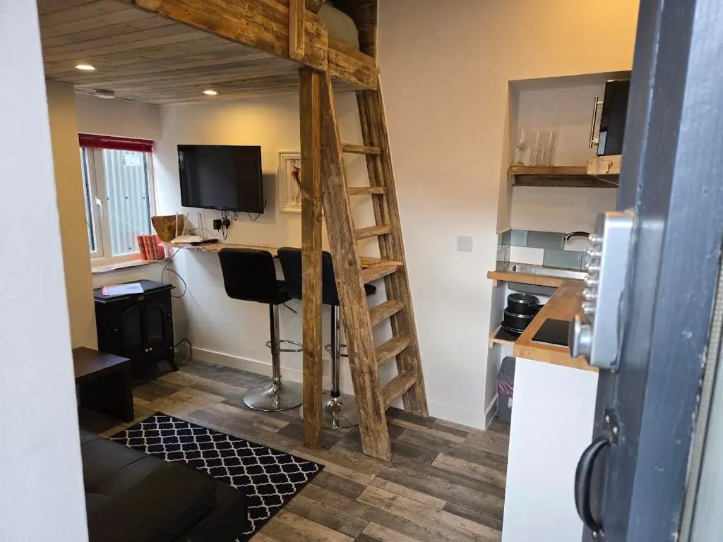 a room with a loft bed and a desk at The Wee Bothy in Tain