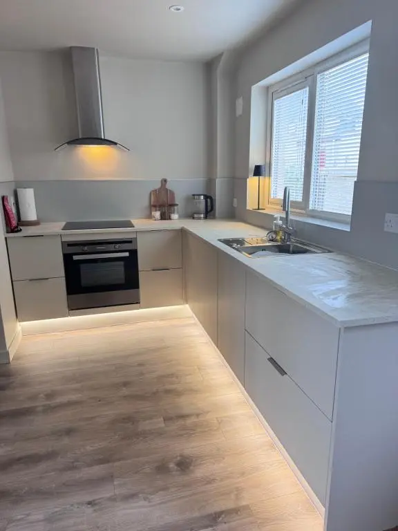 a white kitchen with a sink and a stove at No 67 West Road in Fraserburgh