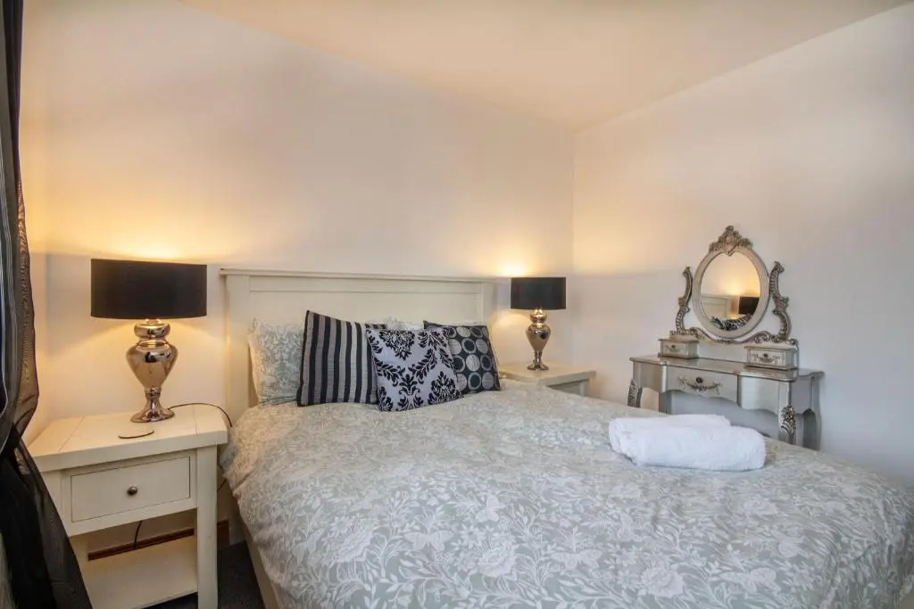 a bedroom with a bed with two lamps and a mirror at Boutique Four Bed Holiday Home in Inverness in Inverness