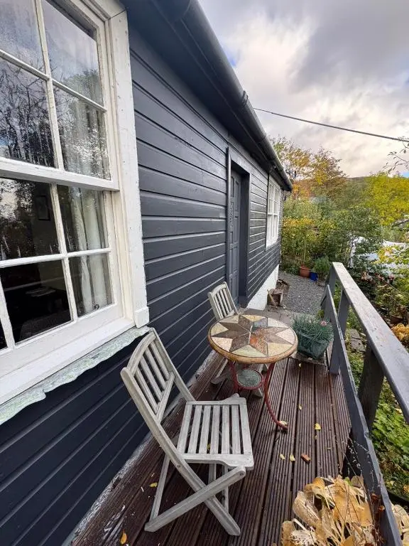 a patio with two chairs and a table on a house at Ullapool Lawyur's patch in Ullapool