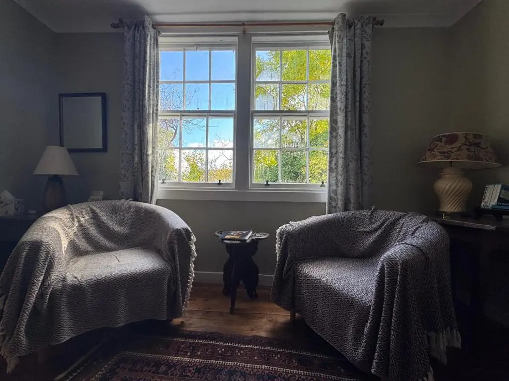 a living room with two chairs and a window at Ullapool Lawyur's patch in Ullapool