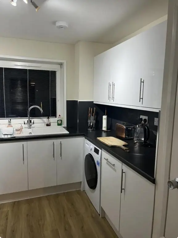 a kitchen with white cabinets and a sink at Townhead Road in Inverurie
