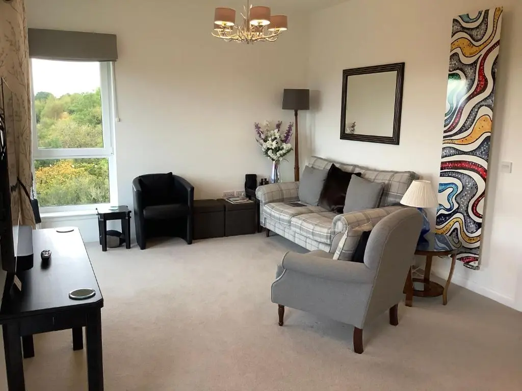 a living room with a couch and a chair at Amazing views of Inverness in Inverness