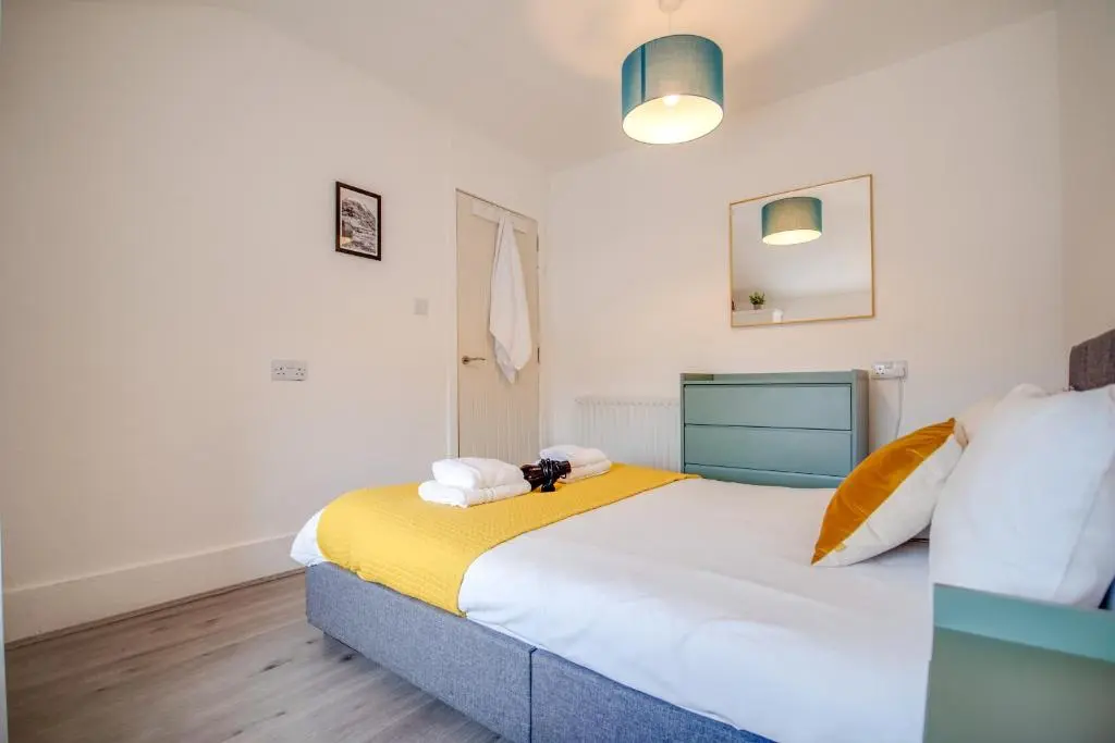 a bedroom with a large bed with a yellow blanket at Comfortable 2-Bedroom Inverness Flat in Inverness